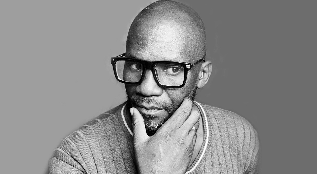 Black-and-white portrait of Meshack looking thoughtfully to the side.